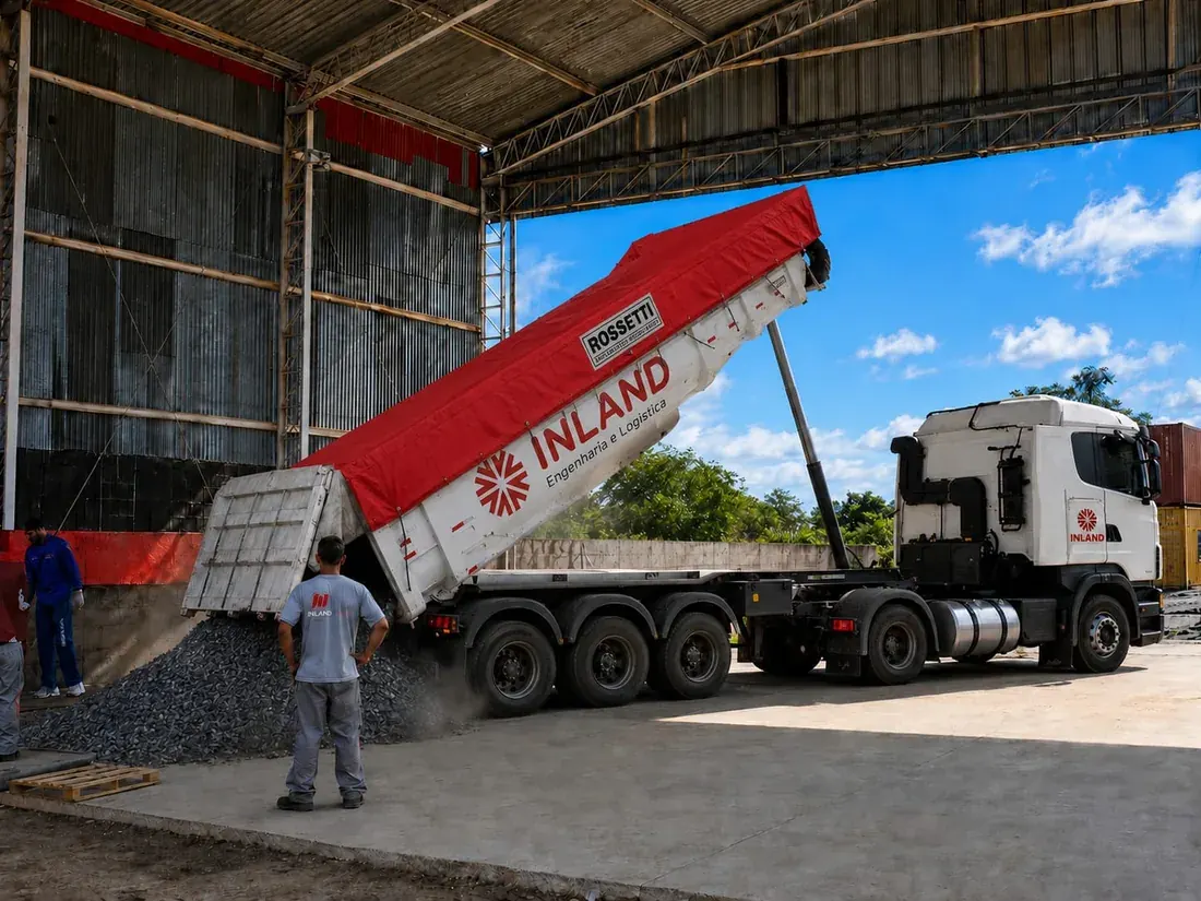 Caminhão basculante da Inland descarregando granel sólido em armazém coberto